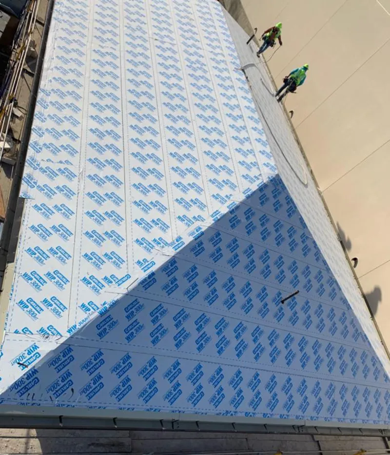 Professional roofers installing underlayment on a metal roof in Great Barrington